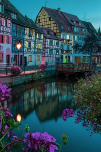 Scenic view of Colmars colorful houses reflecting in the canal during twilight.
